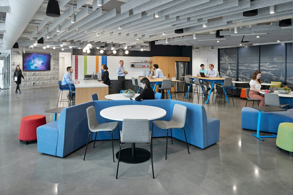 Industrial open workspace lounge with colorful furniture and branding